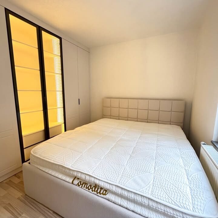 Dhomë gjumi klasike me krevat dru ngjyrë kafe dhe komodina anësore