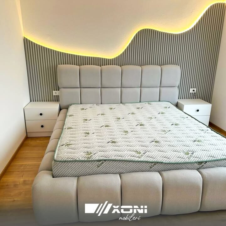 Dhomë gjumi moderne me krevat beige dhe komodina të bardha në Ferizaj