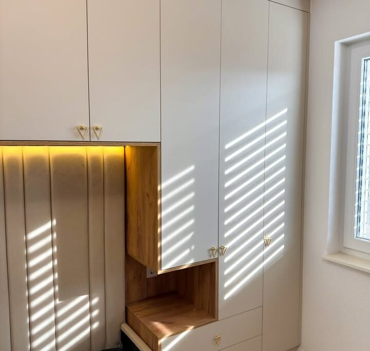 Komodë e bardhë me dritë natyrale në dhomë gjumi elegant